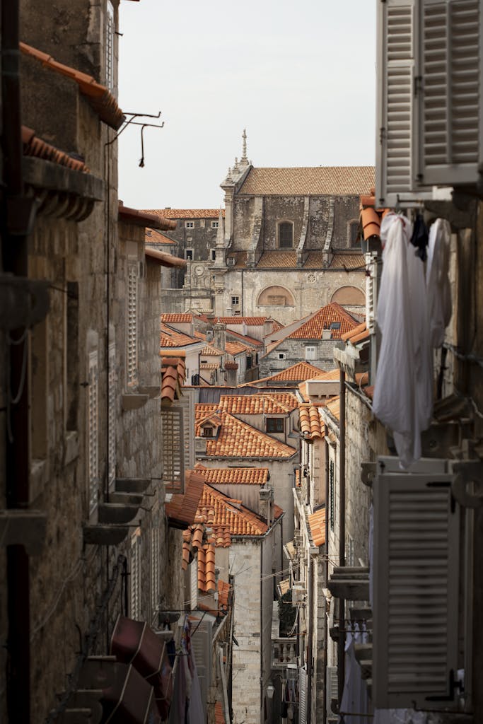 Charming alleyway view of Dubrovnik's iconic medieval architecture and terracotta rooftops.