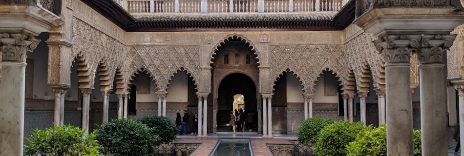 Historic courtyard in the Alcázar of Seville showcasing exquisite Moorish architecture.